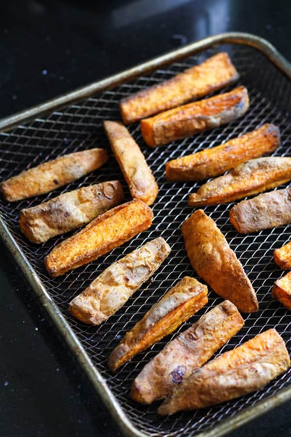cooked sweet potato wedges on a wire rack.