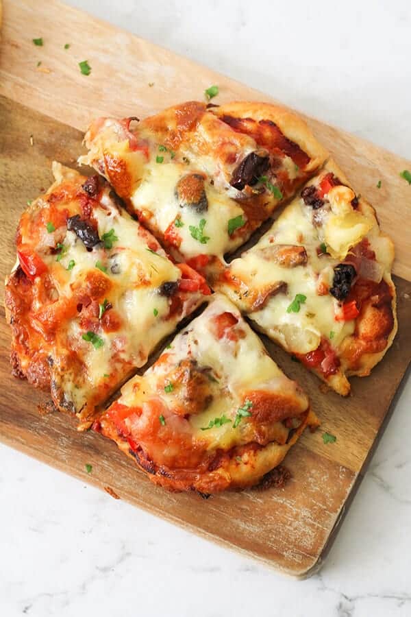 Supreme Pizza on a wooden cutting board.