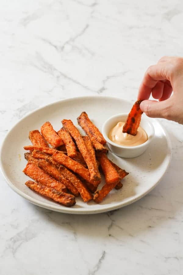 air fryer carrot fries on a white plate.