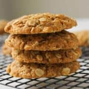 Chewy Anzac biscuits stacked on top of each other on a wire rack.