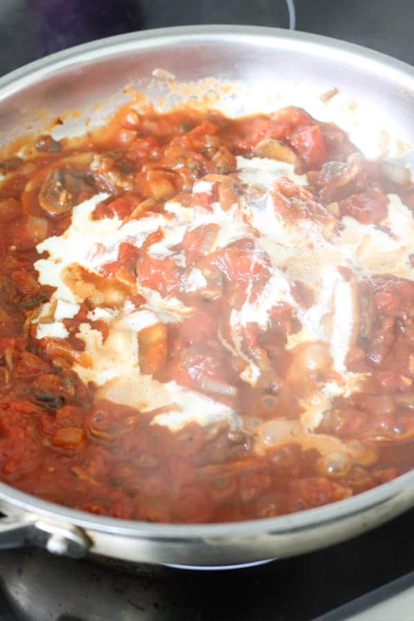 tomato sauce and cream in a frying pan. 