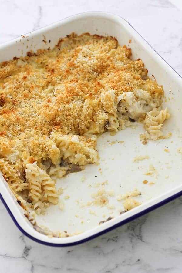 creamy vegetable pasta bake in a white baking dish. 