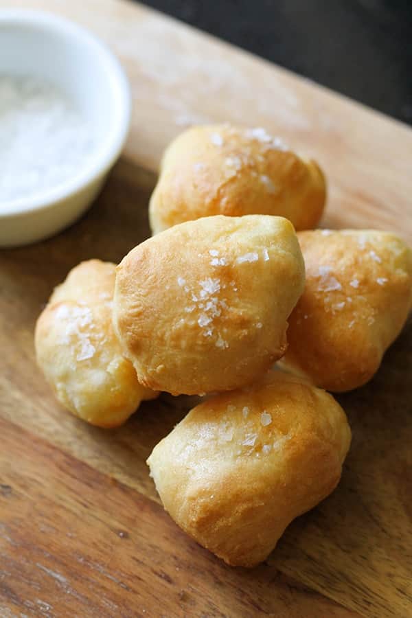 pretzel bites stacked on a wooden serving board.