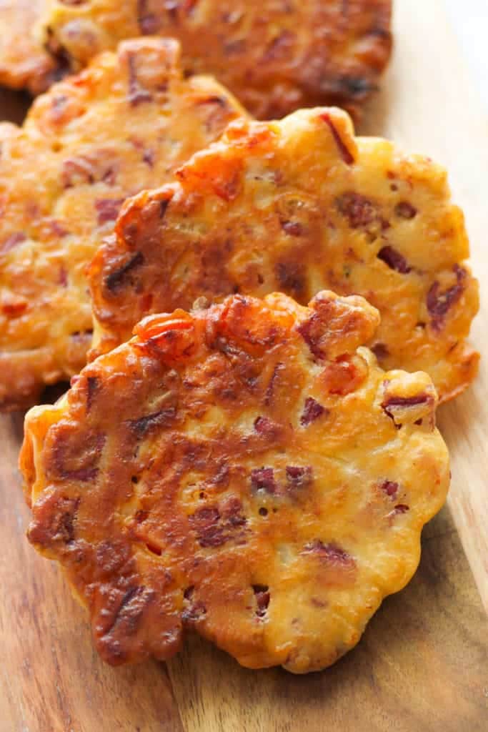 fritters laying on a wooden serving board.