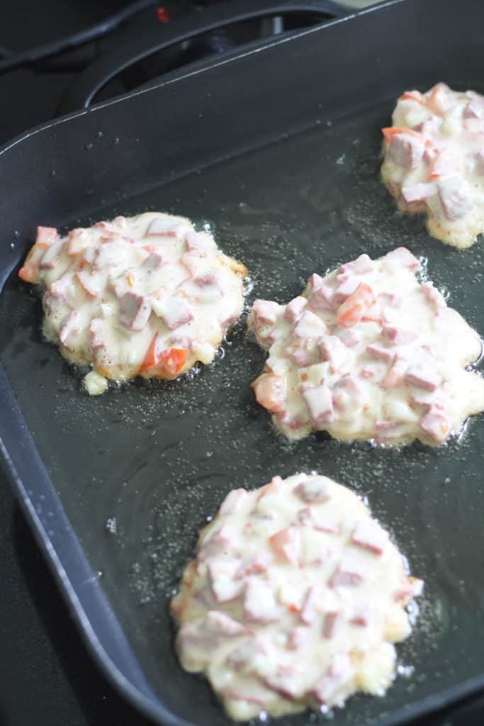 fritters shallow frying in a frying pan.