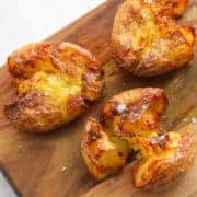 close up on three smashed potatoes on the wooden board.