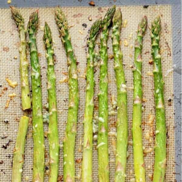 roasted asparagus spears on a baking tray