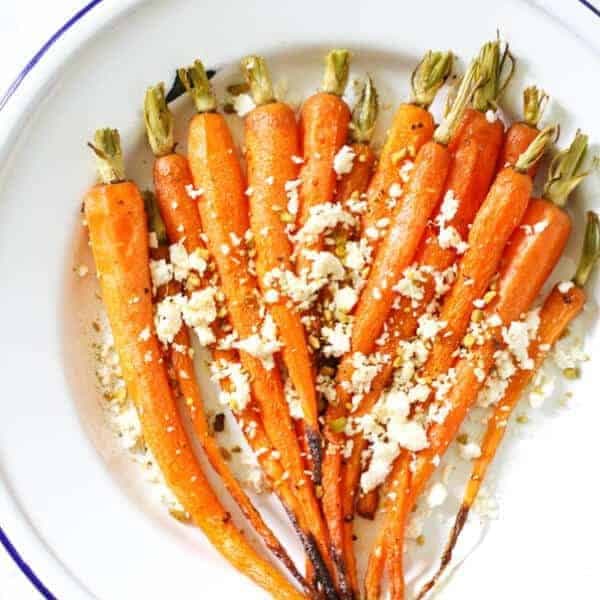 roasted carrots with feta and dukkah on a white plate