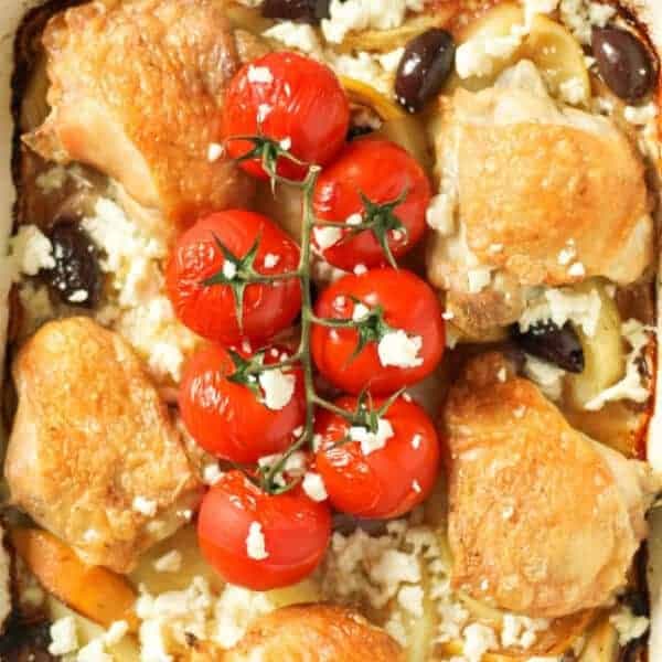 close up image of crispy skin chicken thighs and blistered cherry tomatoes