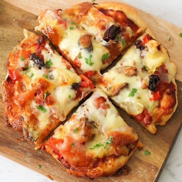Supreme Pizza on a wooden cutting board.
