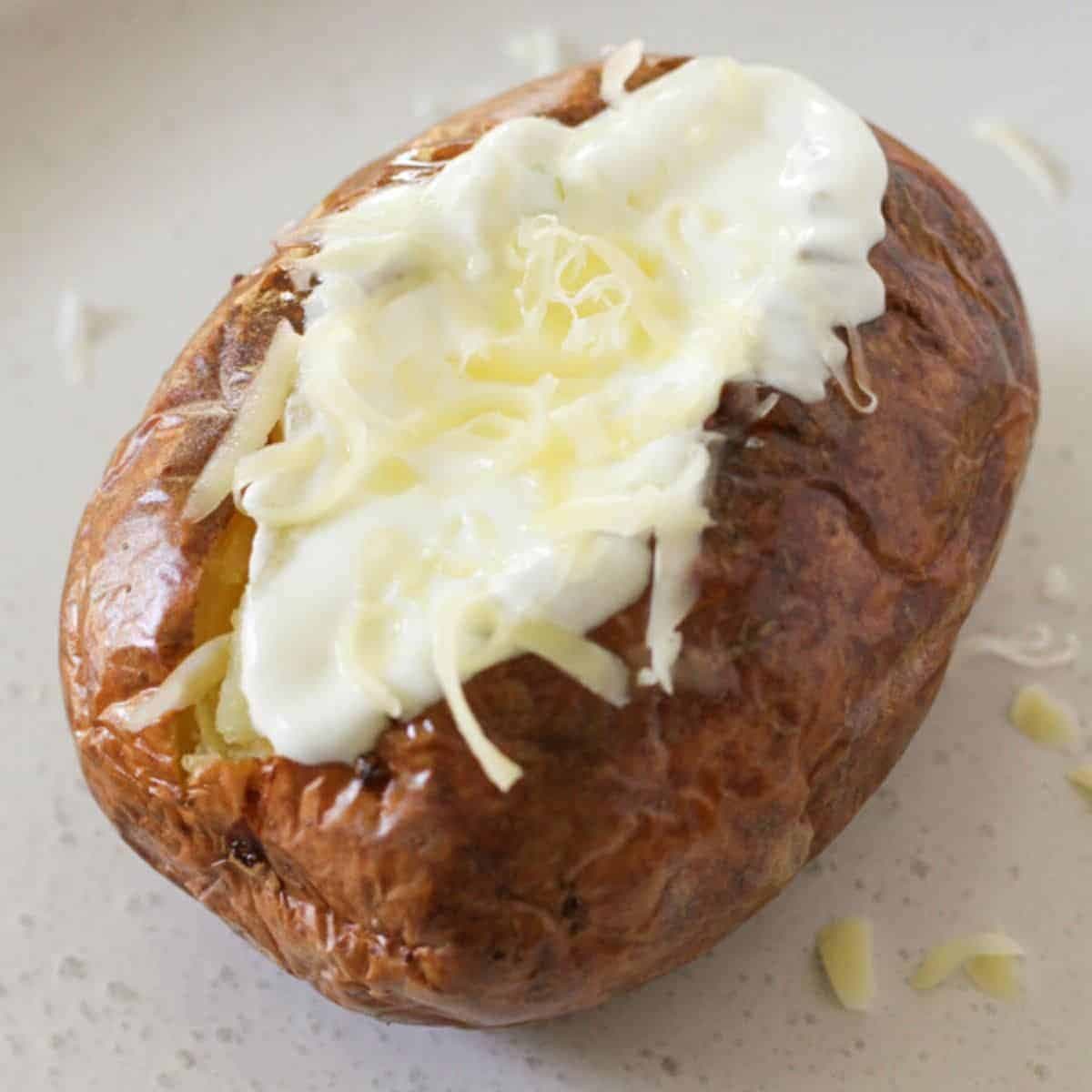 baked potato topped with sour cream and cheese.