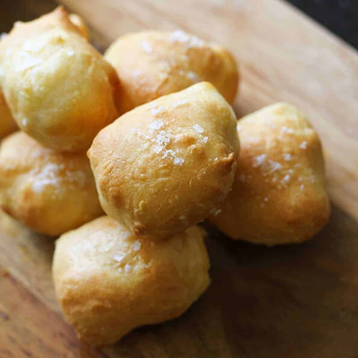 pretzel bites stacked on a wooden serving board.