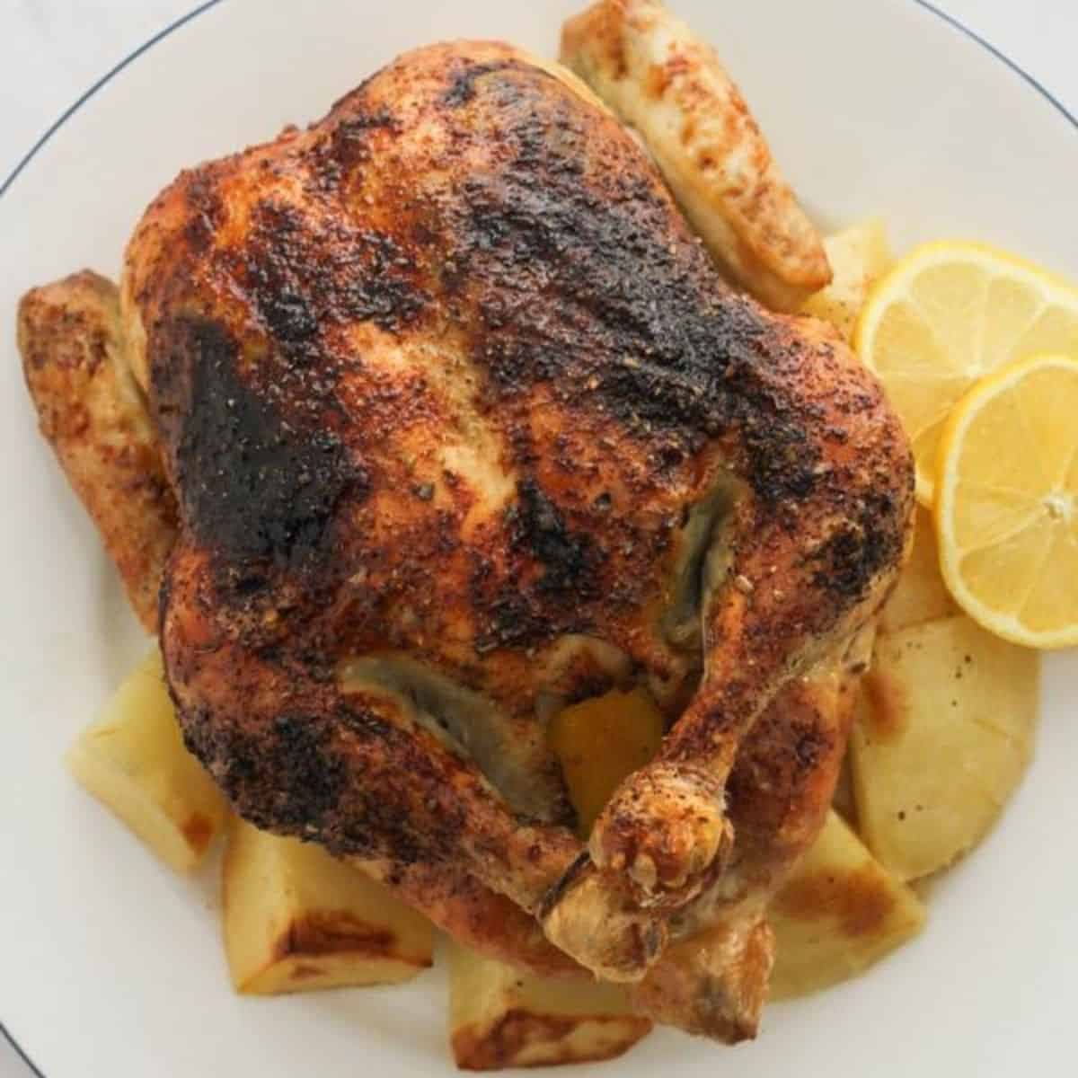 roast chicken and potatoes on a white plate.