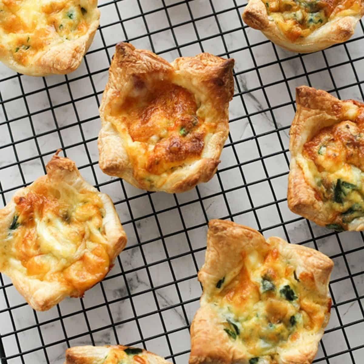 cooked mini quiches on a cooling rack.
