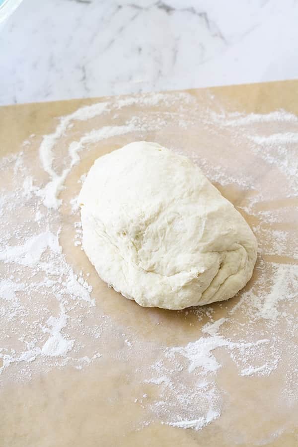 a ball of dough on a piece of parchment paper.