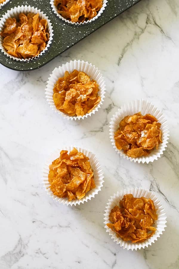 Honey joys in white paper liners on a marble background.