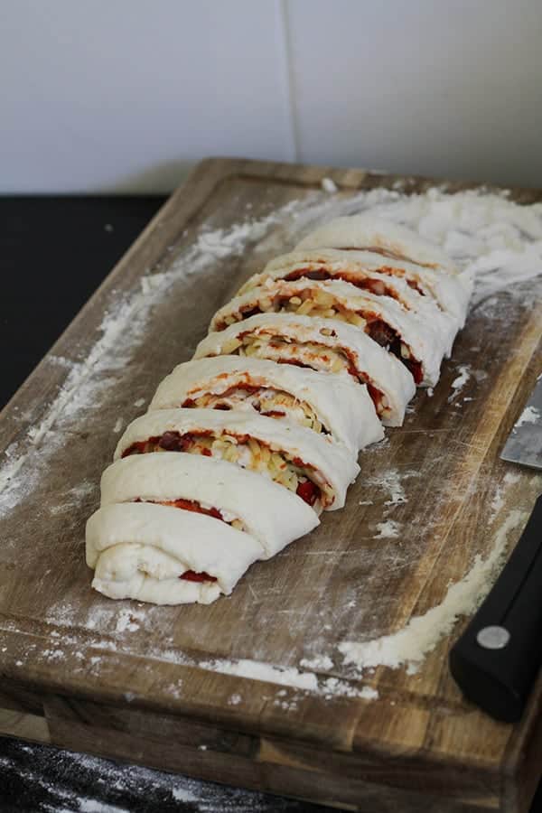 dough cut into rolls on a wooden board.
