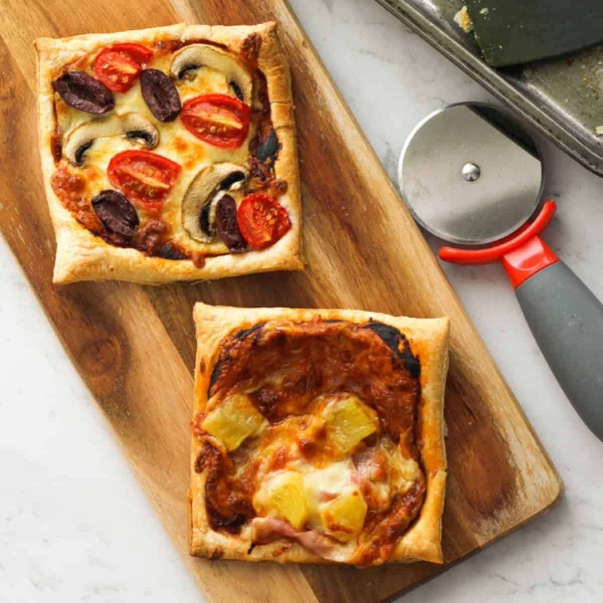 puff pastry pizzas on a wooden board.