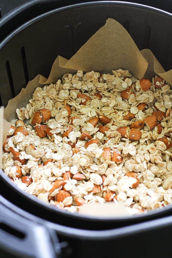 granola in an air fryer basket.