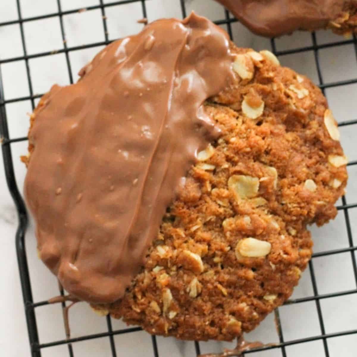 chocolate anzac biscuits on a wire rack.
