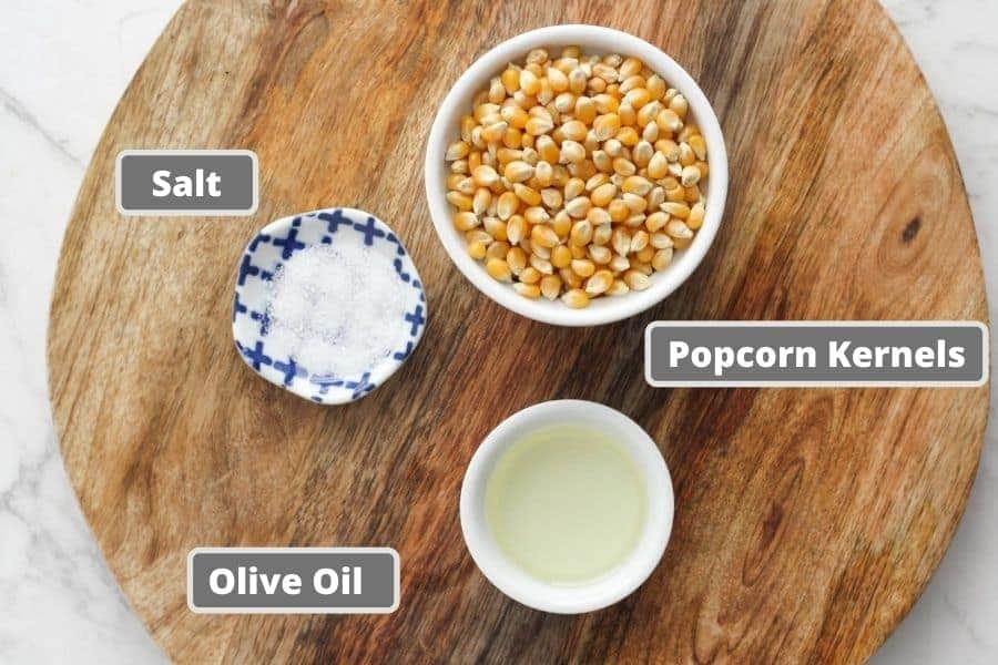 stovetop popcorn ingredients on a wooden board.