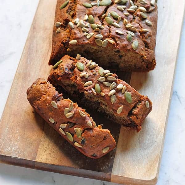 a date loaf sliced on a wooden cutting board