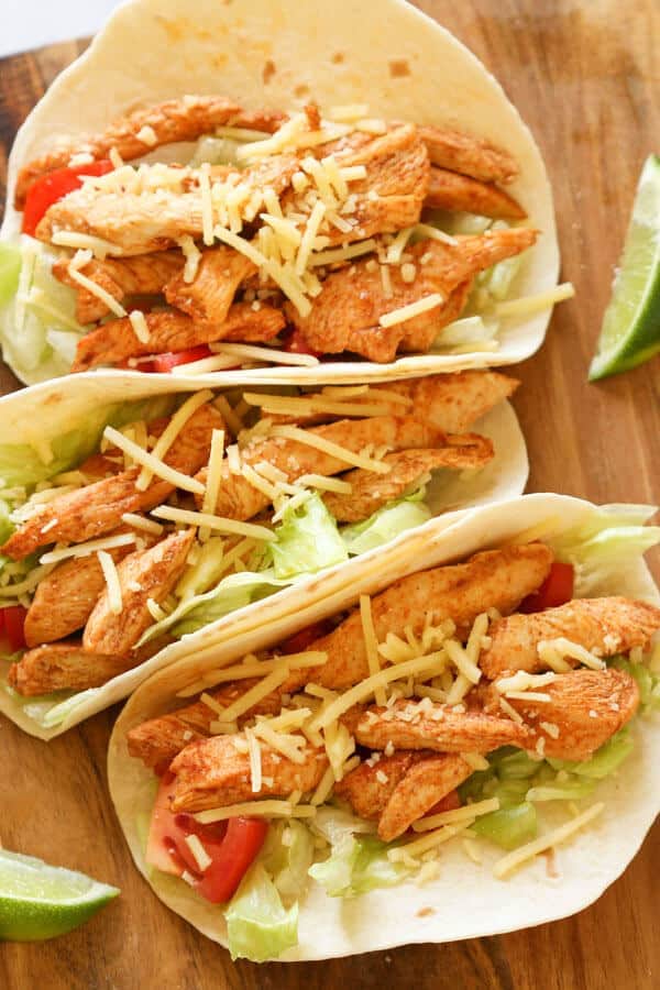 3 chicken tacos on a wooden board