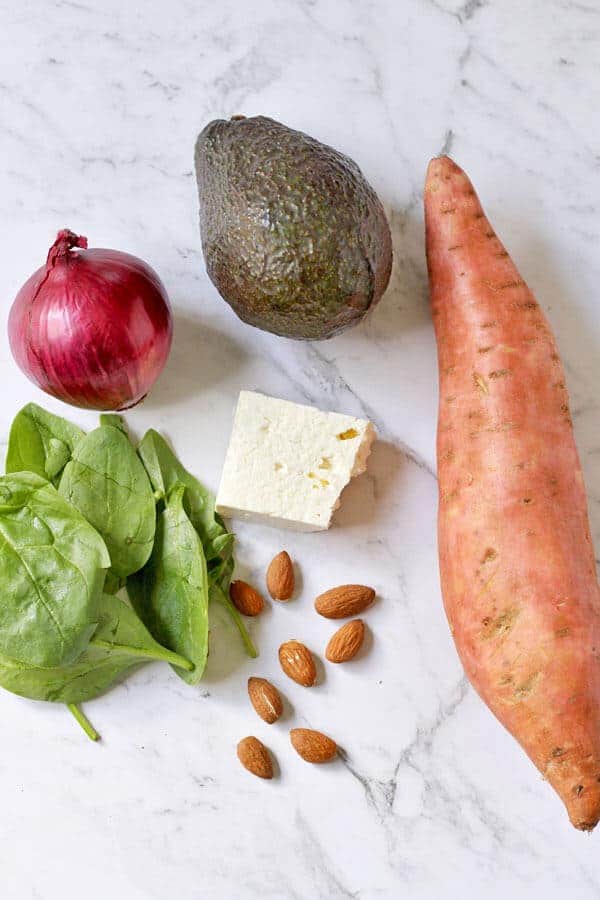 sweet potato, avocado and feta salad ingredients arranged on a marble background