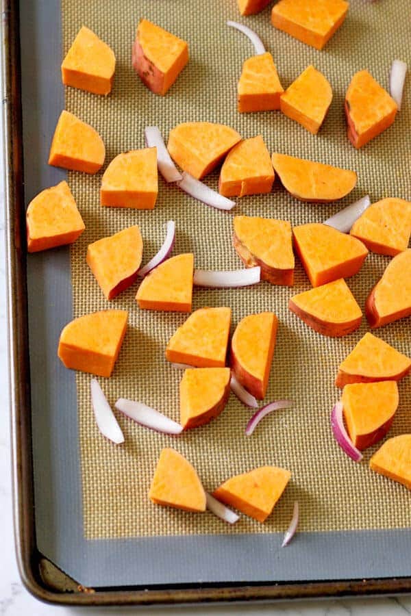 chopped sweet potato and onion on a baking tray