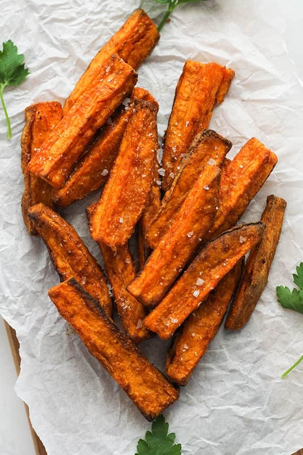 sweet potato wedges on white baking paper covered in salt.