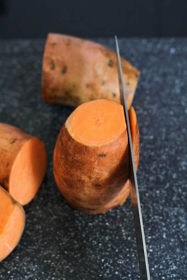 a knife slicing the edge off a sweet potato