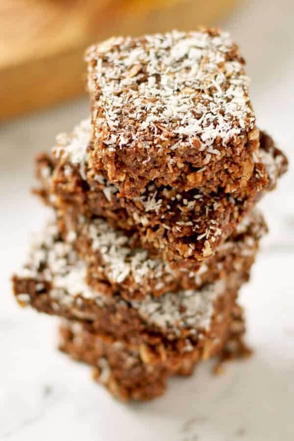 slices of no bake chocolate coconut slice stacked on top of each other