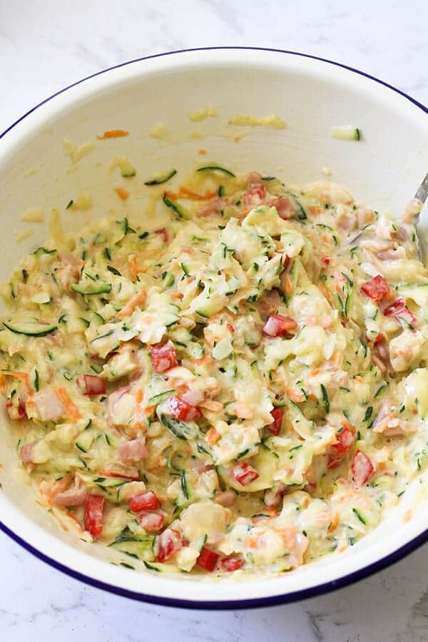 Zucchini and Bacon Slice ingredients in a white mixing bowl. 
