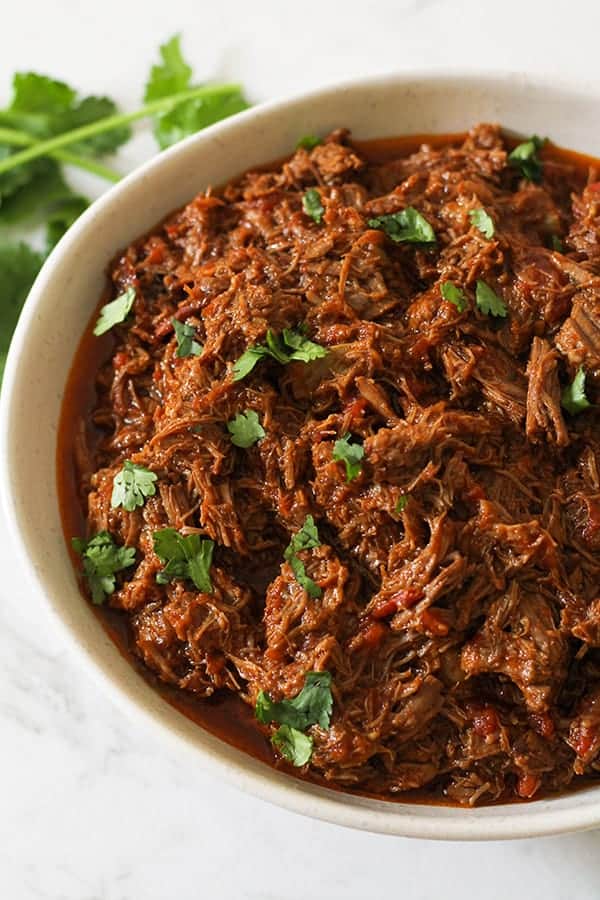 shredded mexican beef in a white bowl.