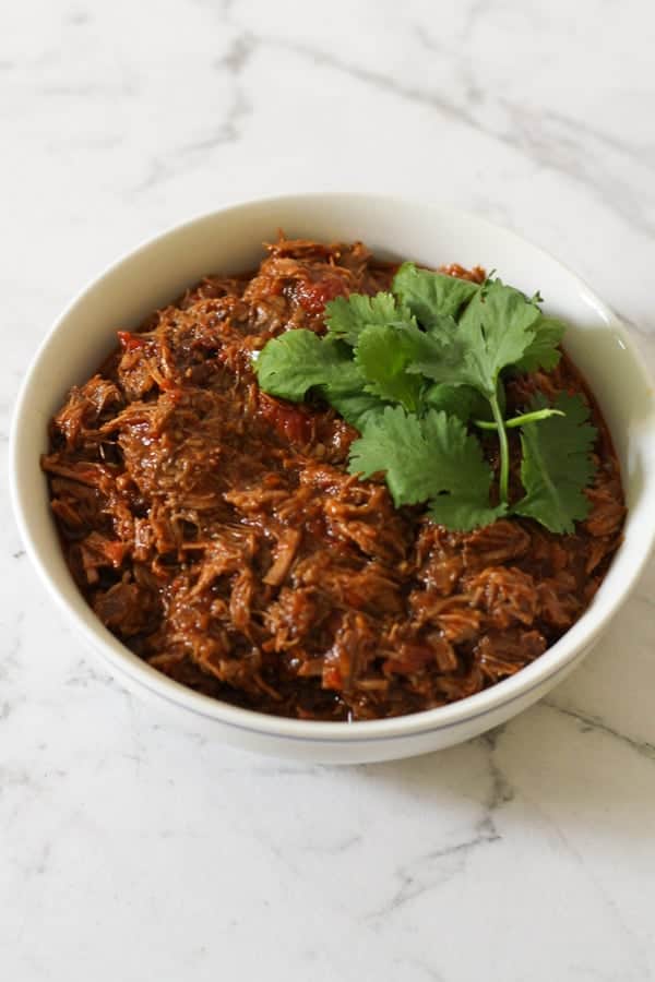 shredded mexican beef in a white bowl.