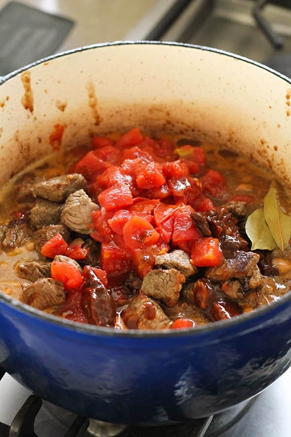 shredded mexican beef ingredients in a blue dutch oven.