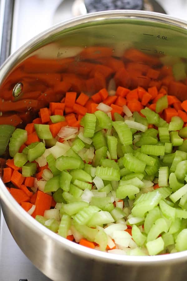 Chopped onions, carrots and celery in a saucepan. 