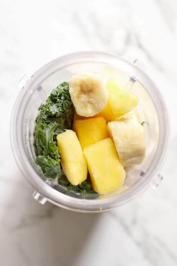 Kale Pineapple Smoothie ingredients in a blender cup
