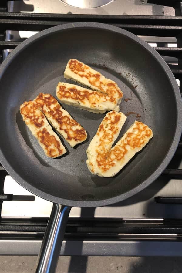 cooked halloumi slices in a skillet.