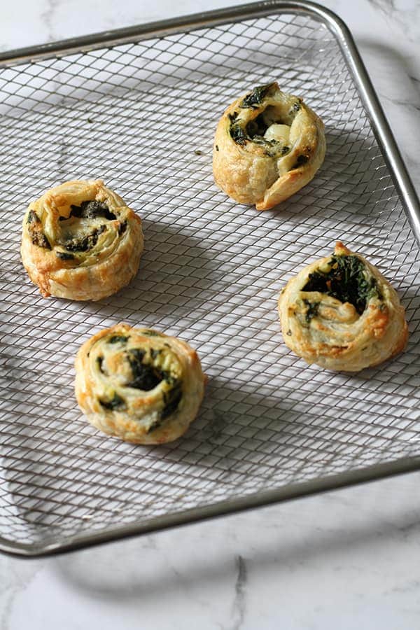 spinach and feta pinwheels on an air fryer tray.