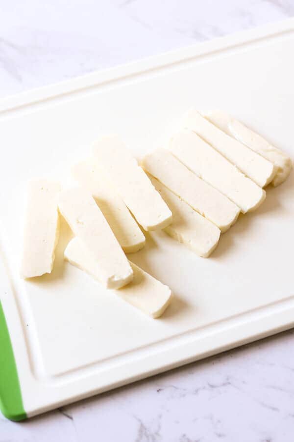 chopped halloumi slices on a cutting board.