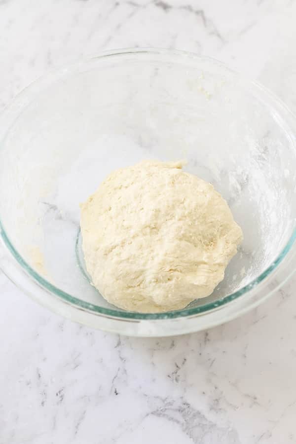 a ball of dough in a glass bowl.