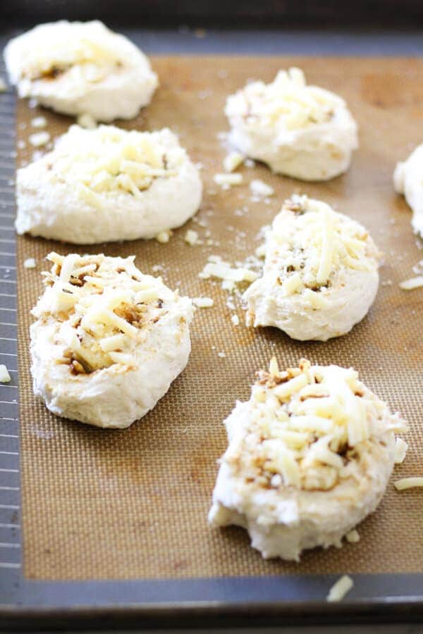 cheese and vegemite scrolls on a baking tray ready for the oven.