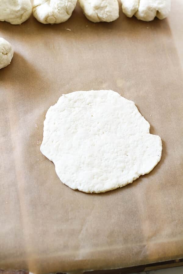 dough flattened out on a board in a circular shape.