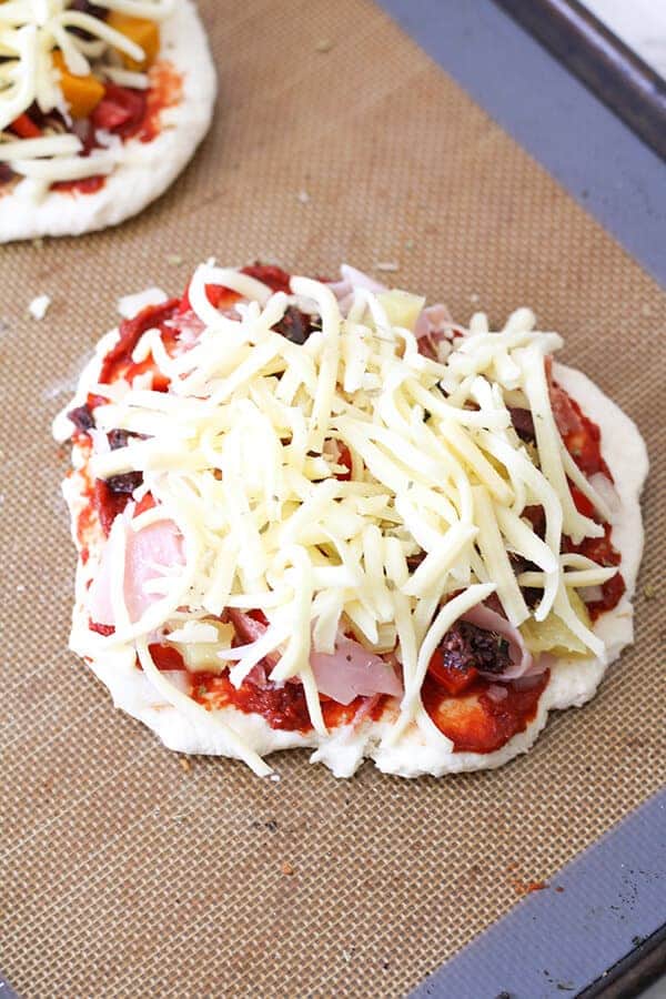 pizza loaded with toppings on a baking tray ready for the oven.