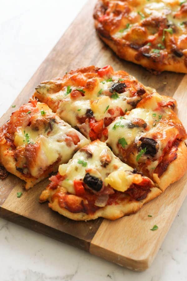 Supreme Pizza on a wooden cutting board.