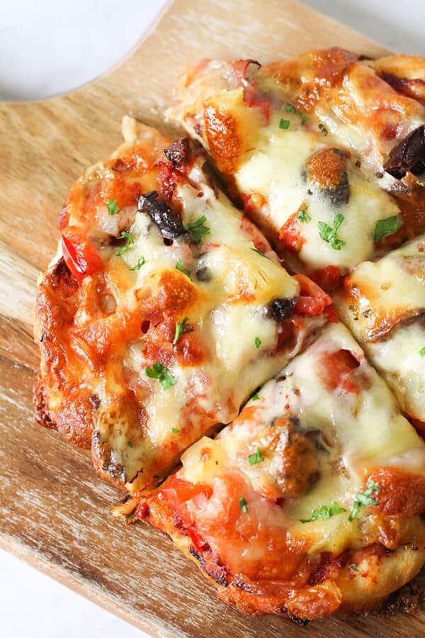 Supreme Pizza on a wooden cutting board.