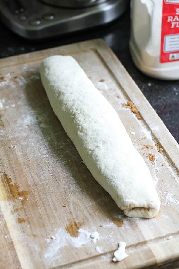 dough rolled into a log on top of a wooden board