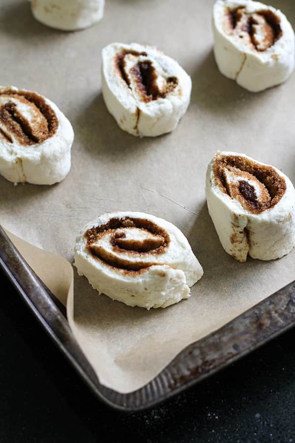 cinnamon rolls on a baking tray ready for the oven.