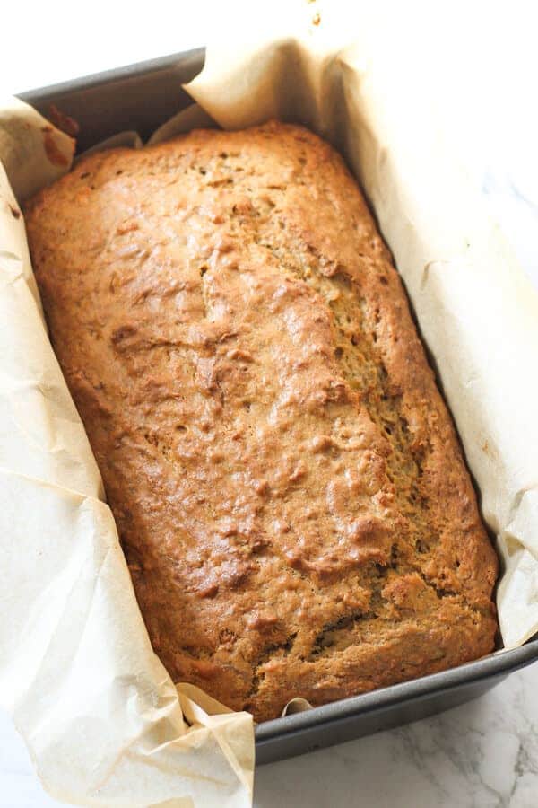 banana bread in a loaf pan straight out of the oven. 